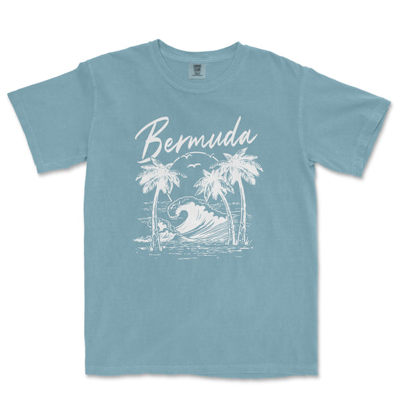a blue t - shirt with a picture of a wave and palm trees