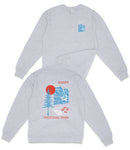 a grey sweatshirt with a graphic design on the back, depicting a mountain landscape with a red sun and blue sky.