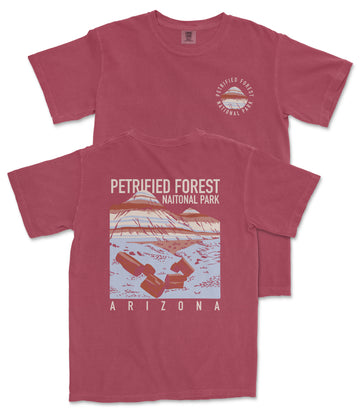 A red t-shirt with a graphic design depicting a mountain range and the text "PETRIFIED FOREST NATIONAL PARK ARIZONA" printed on it.