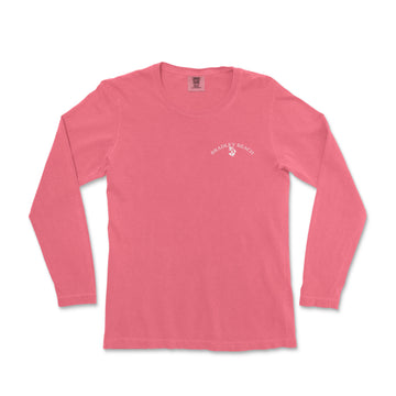 a women's pink long sleeve shirt with white writing on the chest