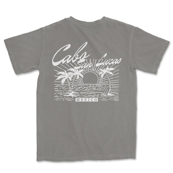a gray t - shirt with a picture of a sunset and palm trees