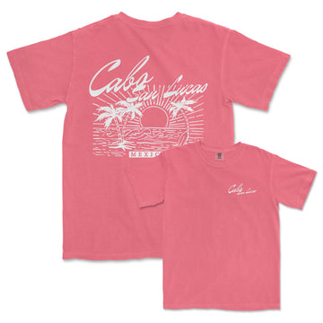 a pink shirt with a picture of a sunset and palm trees